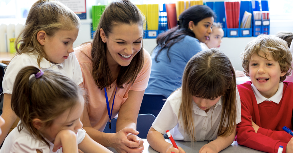 teacher-and-a-group-of-young-students-smiling