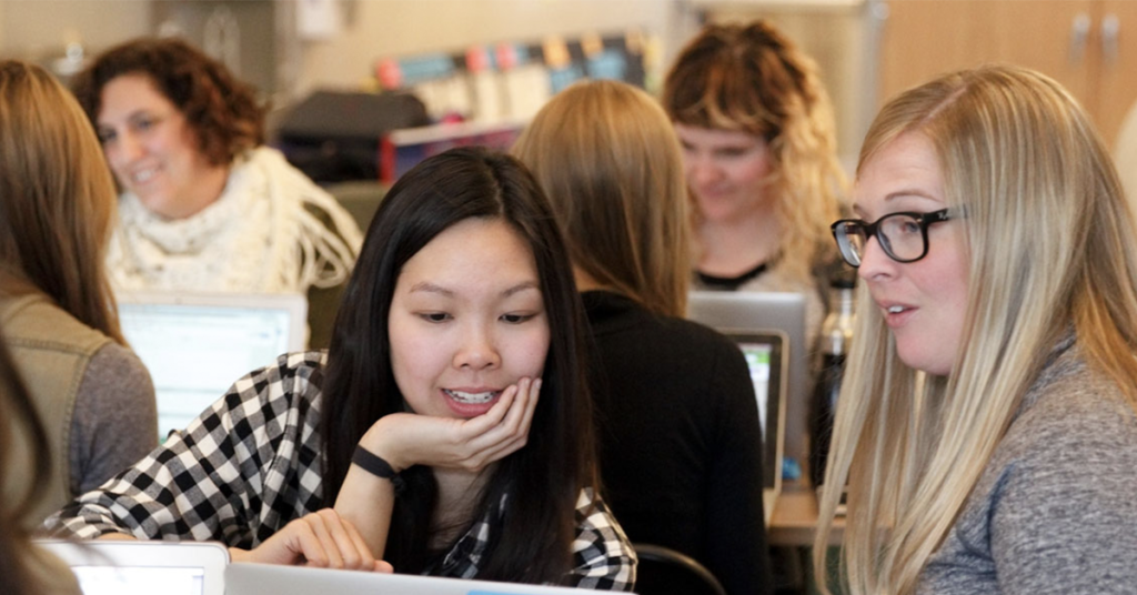 two-women-looking-at-a-laptop-and-collaborating